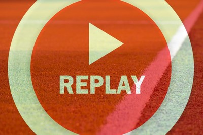 Red Circular Replay Button Against Football Pitch Sideline