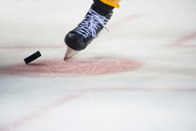 Boot of Ice Hockey Player with Puck