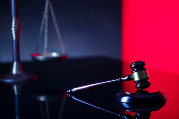 Gavel and Scales Against Black and Red Background